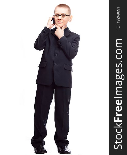 Ten year old blond boy wearing a costume talking on the cellphone, isolated against white. Ten year old blond boy wearing a costume talking on the cellphone, isolated against white