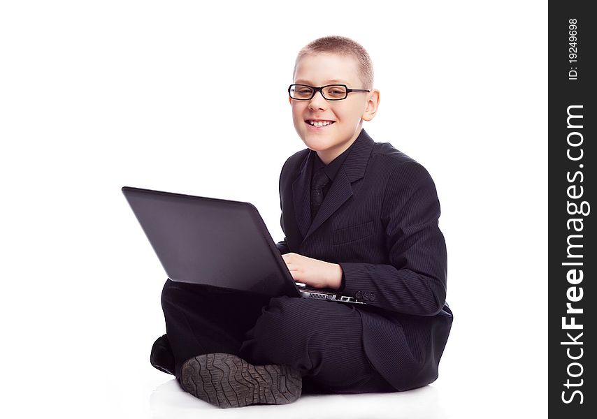 Ten year old blond boy wearing a costume with a laptop. Ten year old blond boy wearing a costume with a laptop