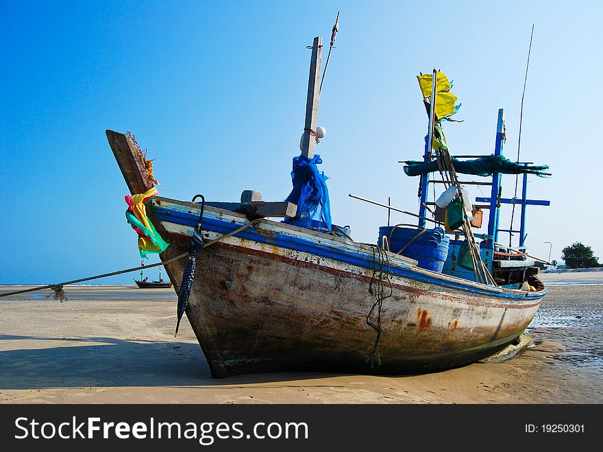 Fisherman boat on the sea shore , with bright blue sky background