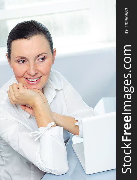 Smiling young business woman using laptop