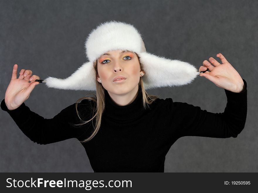 Woman in winter hat on gray background