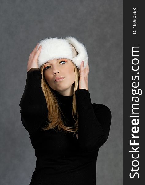 Woman in winter hat on gray background