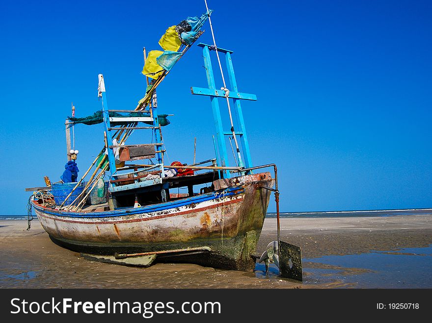 Fisherman boat on the sea shore , with bright blue sky background