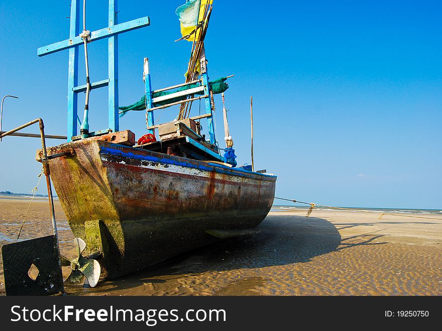 Fisherman boat on the sea shore , with bright blue sky background