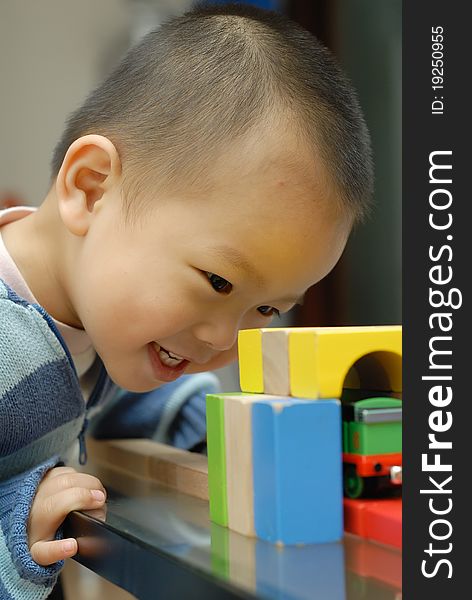 A chinese boy is playing the building block.