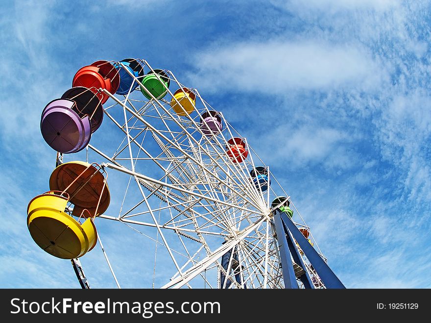 Brightly colored Ferris wheel against the blue sky