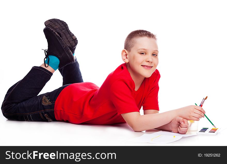 Cute ten year old boy painting with watercolor, isolated against white