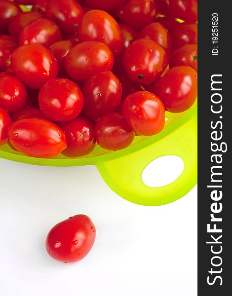 Red tomatoes in the  green colander.