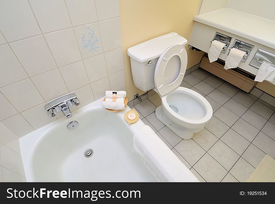 Clean and luxurious white toilet and bathtub area. Clean and luxurious white toilet and bathtub area.