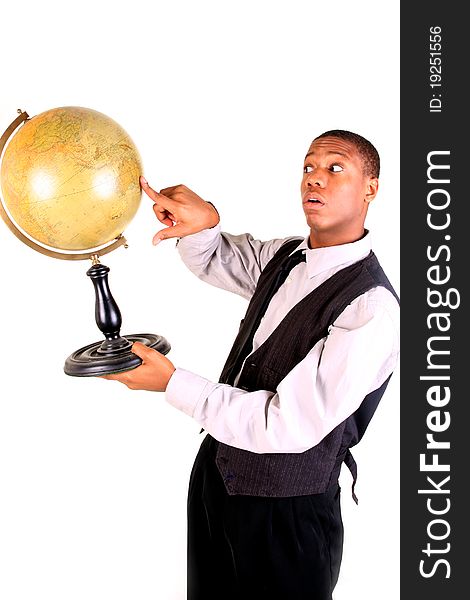 A young man pointing at a globe and looking surprised. A young man pointing at a globe and looking surprised