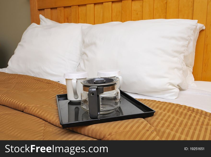 Coffee or tea maker and cups on bed for relaxed breakfast. Coffee or tea maker and cups on bed for relaxed breakfast.