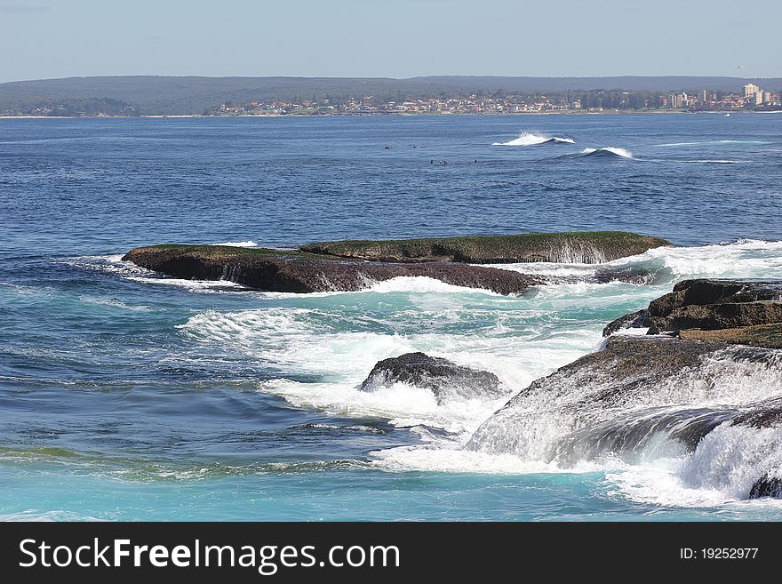 Blue ocean waters with waves washing over the rocks - at the seaside town Cronulla (Australia). Blue ocean waters with waves washing over the rocks - at the seaside town Cronulla (Australia)