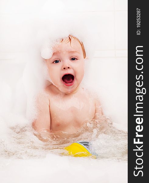 Cute one year old boy taking a relaxing bath with foam. Cute one year old boy taking a relaxing bath with foam