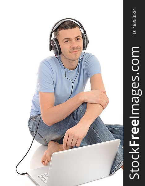 Young handsome man listening to music in headphones from computer. isolated. Young handsome man listening to music in headphones from computer. isolated