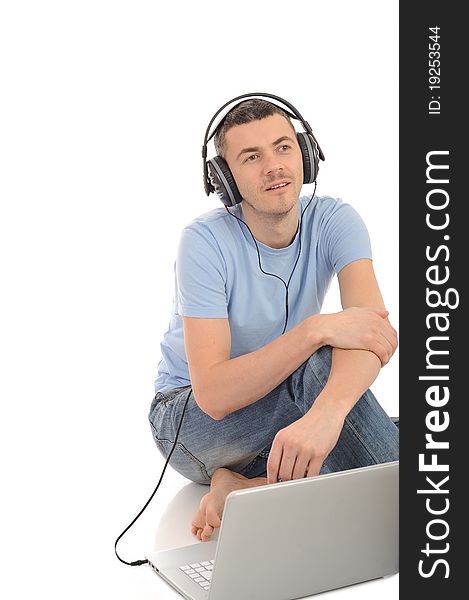 Young handsome man listening to music in headphones from computer. isolated. Young handsome man listening to music in headphones from computer. isolated