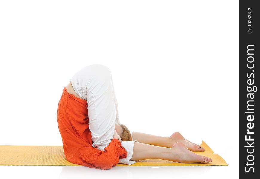 Series or yoga photos. young woman in halasana pose on yellow pilates mat. Series or yoga photos. young woman in halasana pose on yellow pilates mat