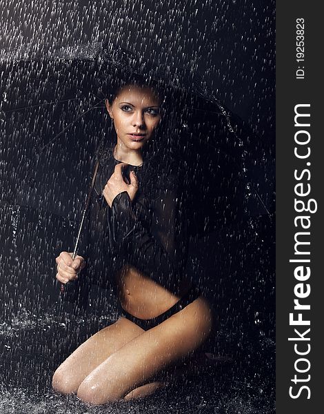 Fashion girl in aqua studio with umbrella.