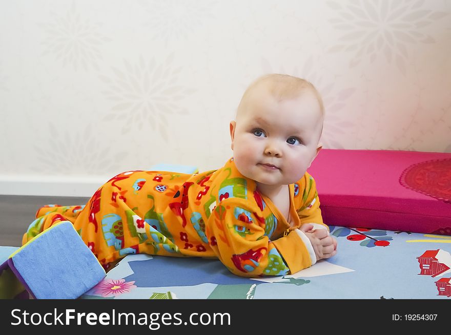 Cute 8 months old baby lying on bed in casual home enviroment