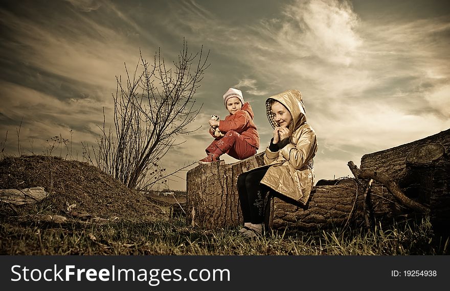 Two young girls at abandoned broken trees area. Two young girls at abandoned broken trees area