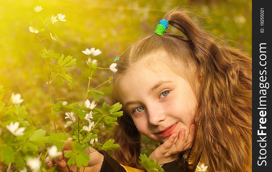 Little girl portrait at spring forest flowers