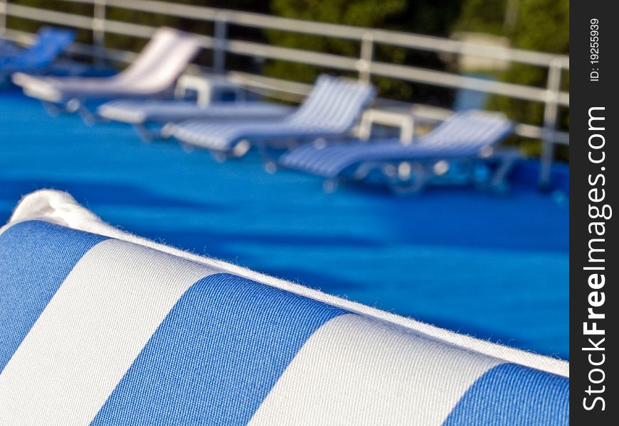 Row of lounge chairs, with blue and white stripes.