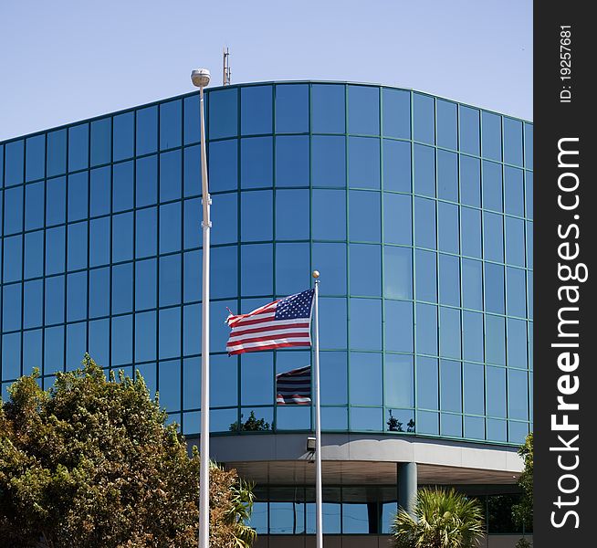 U.S. flag relects in the windows of a glass building. U.S. flag relects in the windows of a glass building