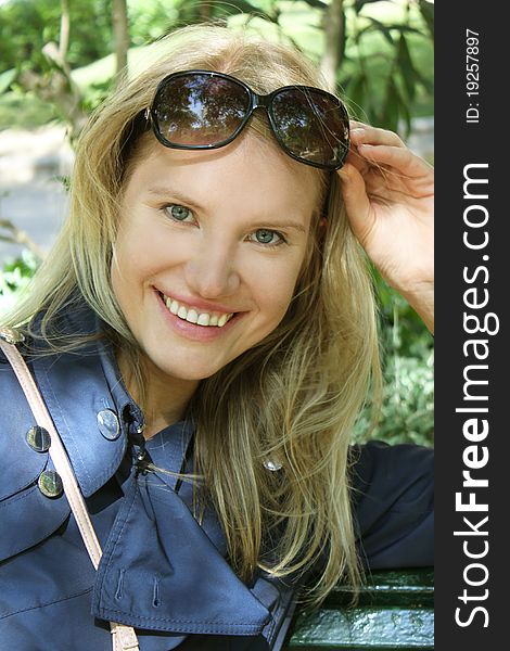 A young woman smiling on a park bench