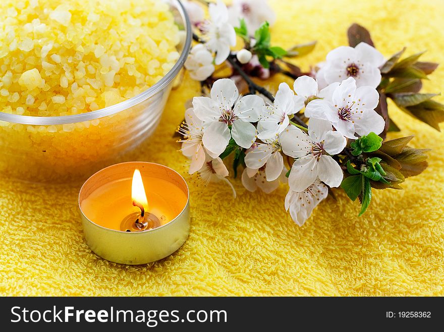 Yellow sea salt with yellow candles on a yellow towel. Yellow sea salt with yellow candles on a yellow towel