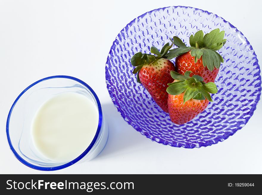 Blue cup of strawberries and glass of milk, view of above. Blue cup of strawberries and glass of milk, view of above