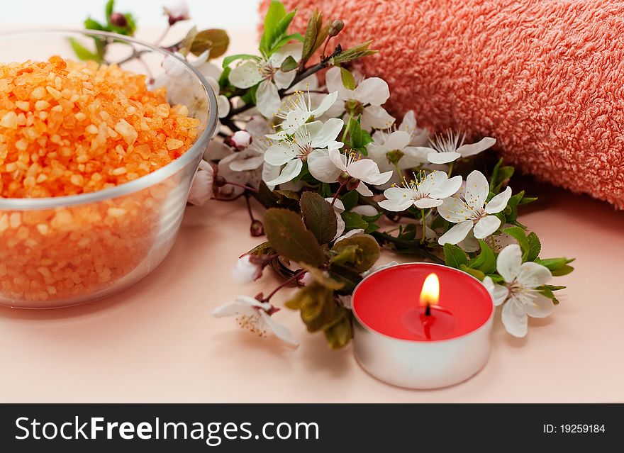 Red sea salt with a red candle and a red towel on a pink background. Red sea salt with a red candle and a red towel on a pink background