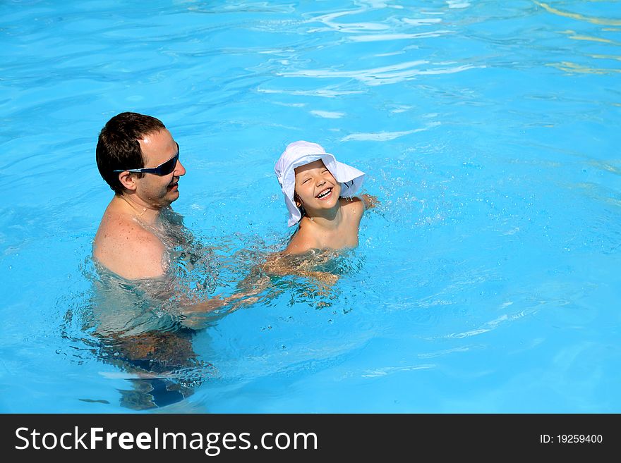 Dad teaches his daughter to swim in the pool. Dad teaches his daughter to swim in the pool