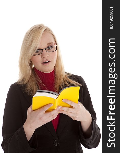 A young woman reading and studying with a shocked expression on her face. A young woman reading and studying with a shocked expression on her face.