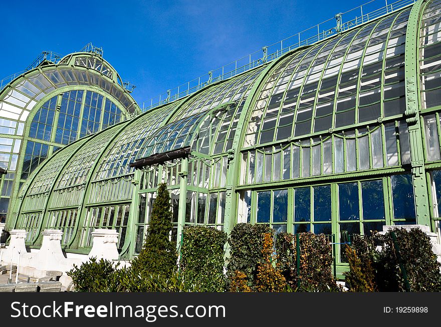 An antique greenhouse with aged steel under a clear blue sky. An antique greenhouse with aged steel under a clear blue sky