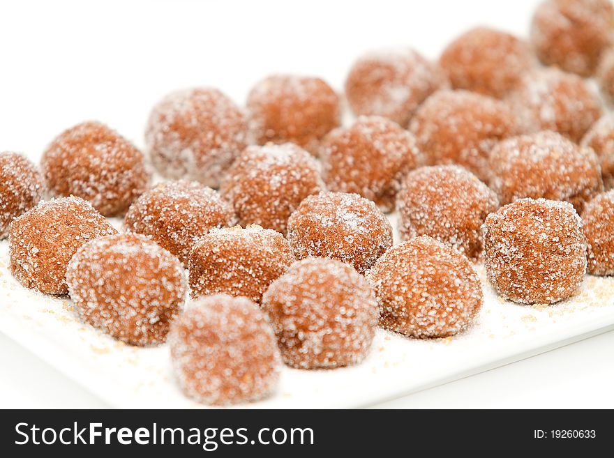 Chocolate balls covered with sugar on a white plate