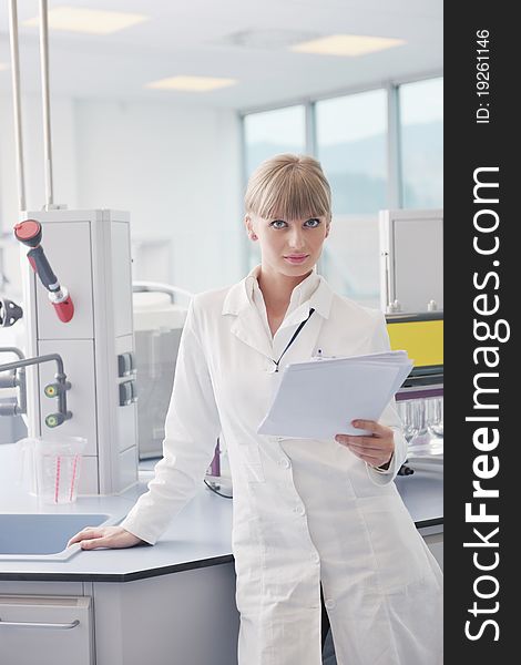 Doctor student female researcher holding up a test tube in chemistry bright labaratory. Doctor student female researcher holding up a test tube in chemistry bright labaratory