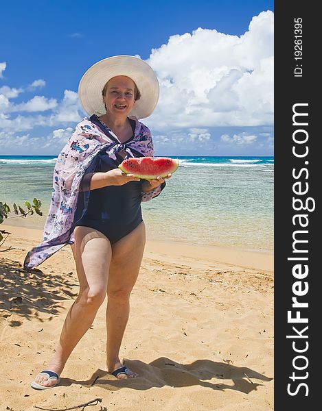 Woman with a slice of watermelon on the background of the Atlantic Ocean. Holidays in the Caribbean.