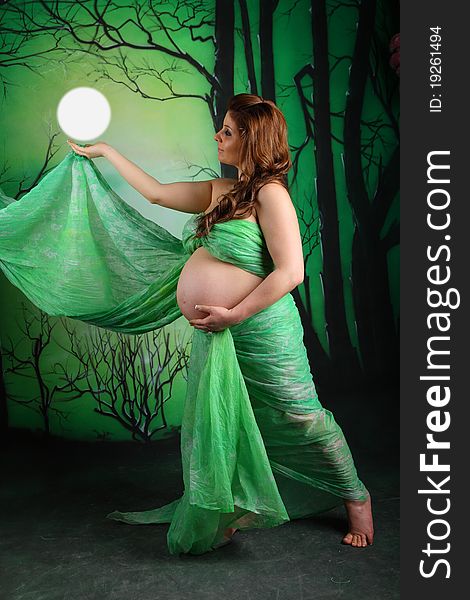 Side view of a pregnant woman with a green chiffon. Side view of a pregnant woman with a green chiffon
