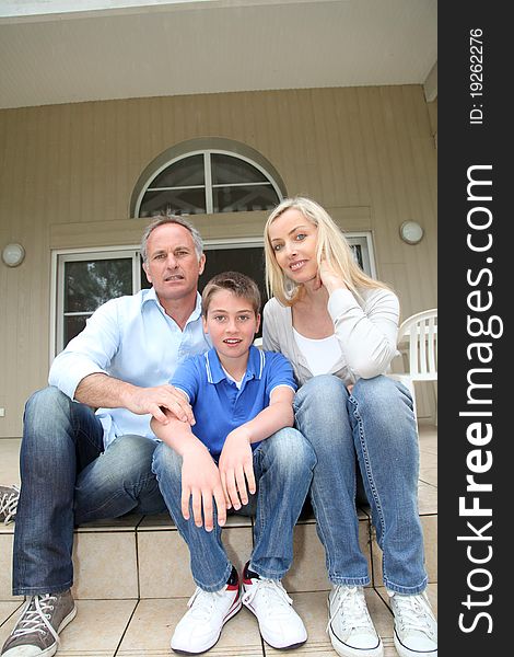 Portrait of family sitting on the front door stairs. Portrait of family sitting on the front door stairs