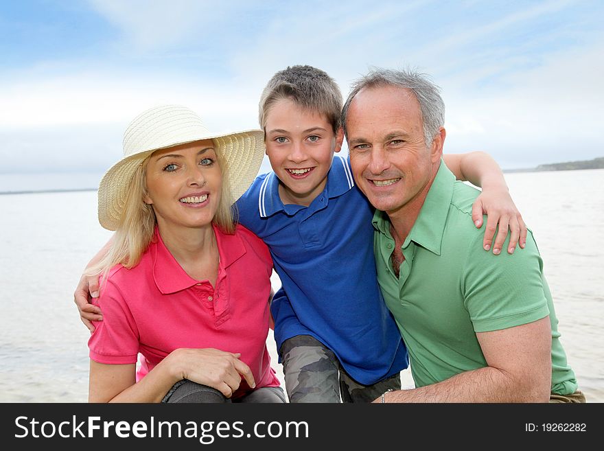 Portrait of happy family kneeling by a lake. Portrait of happy family kneeling by a lake