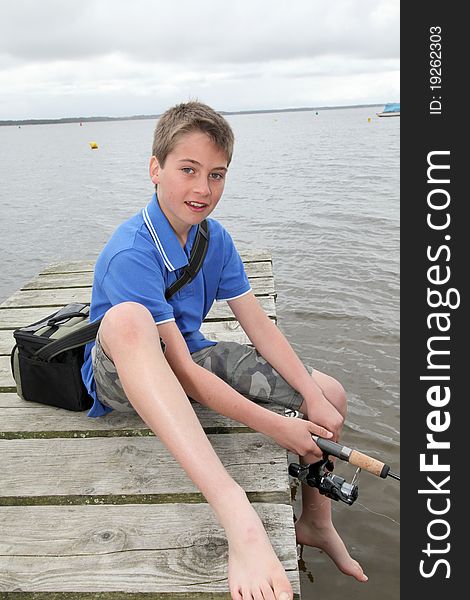 Kid sitting on a pontoon with fishing rod. Kid sitting on a pontoon with fishing rod