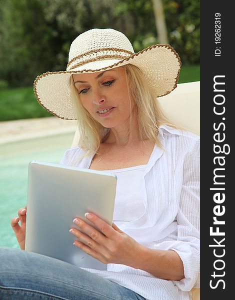 Woman resting in long chair with touchpad. Woman resting in long chair with touchpad