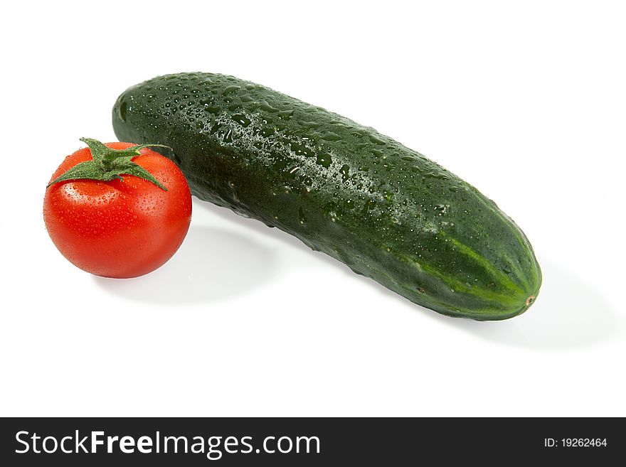 A Tomato with a single isolated cucumber with shadow. A Tomato with a single isolated cucumber with shadow.