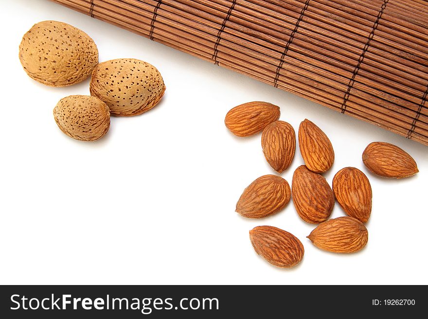 Almond nuts and kernels with brown bamboo mat. Almond nuts and kernels with brown bamboo mat