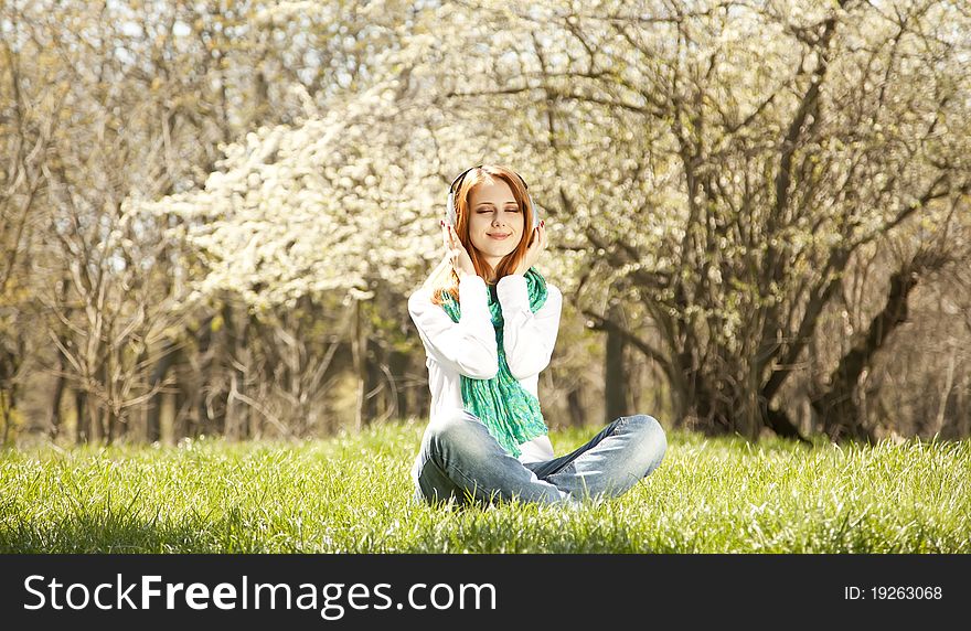 Redhead Girl With Headphone In The Park