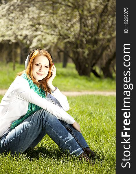 Redhead girl with headphone in the park