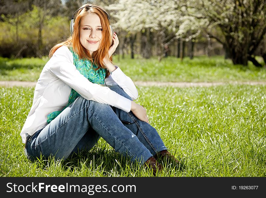 Redhead Girl With Headphone In The Park