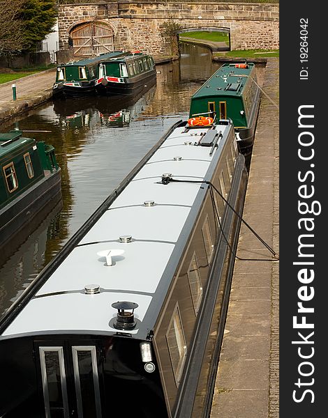 Five green narrow-boats moored up on the Llangollen canal. Five green narrow-boats moored up on the Llangollen canal