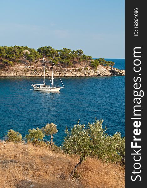 Whtie sailing boat, anchored in a gulf on the Mediteranian Sea in Greece. Whtie sailing boat, anchored in a gulf on the Mediteranian Sea in Greece.