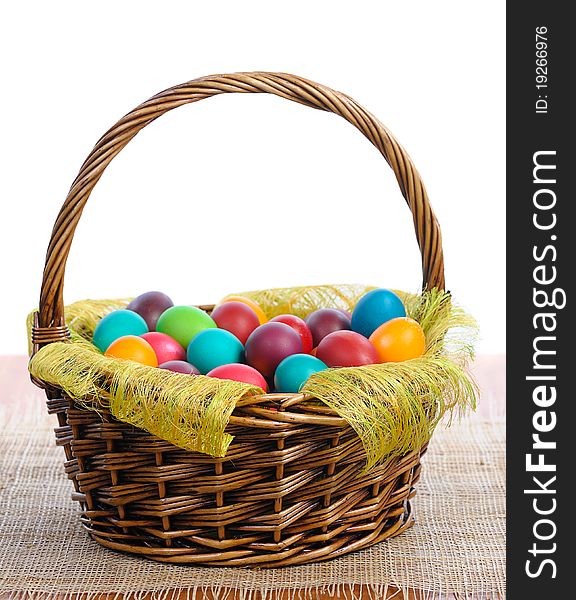 Colorful easter eggs in basket on white background