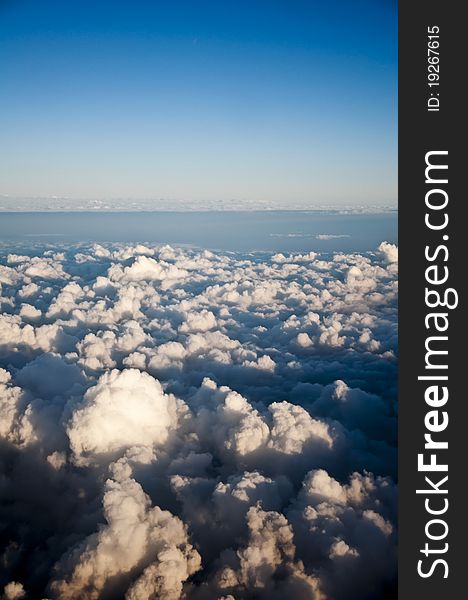 A photograph takem from above the clouds showing a variety of different cloud formations.